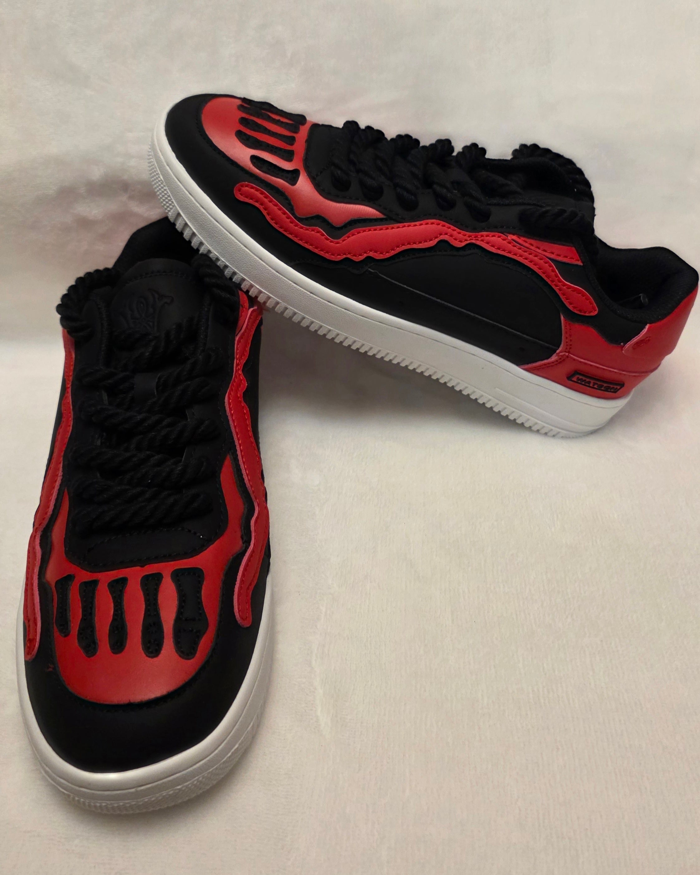 Bred Bones red and black skeleton sneakers on white background