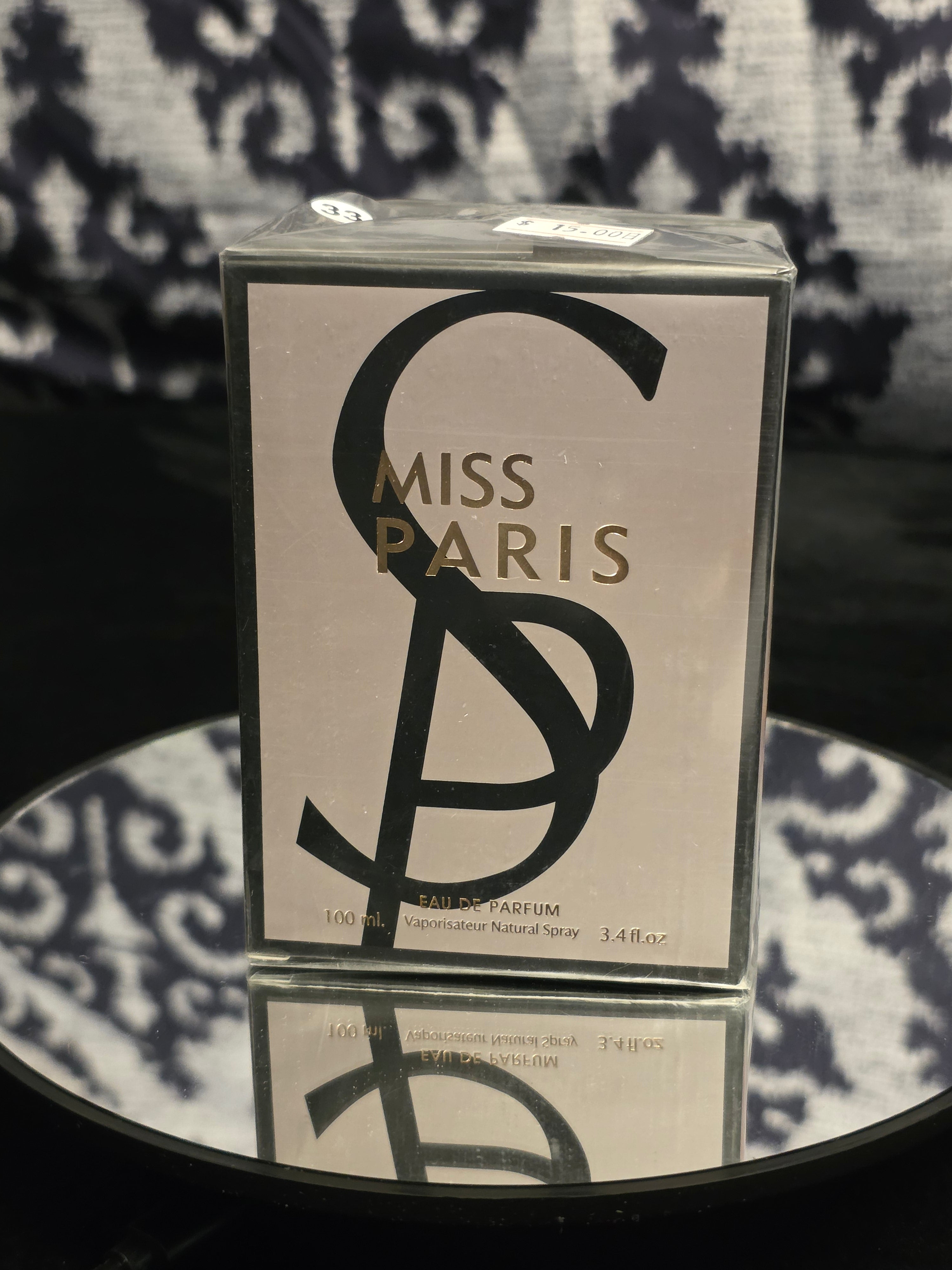 Miss Paris Eau de Parfum 100mL box - sleek warm greige taupe packaging with bold oversized black SP monogram crest and gold MISS PARIS serif typography