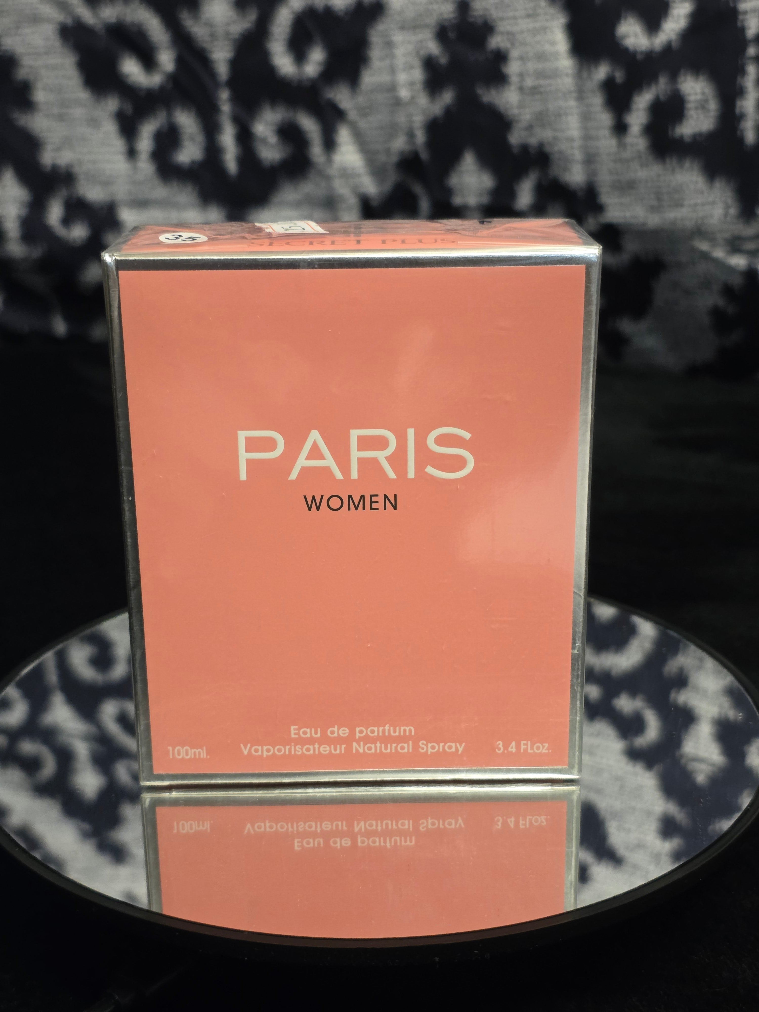 Paris Women Eau de Parfum 100mL box - warm terracotta salmon pink packaging with clean cream PARIS WOMEN serif typography and silver mirror edge trim
