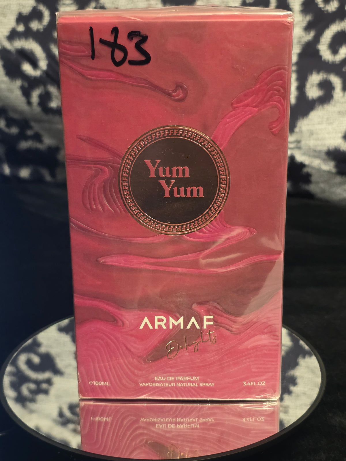 Armaf Delights Yum Yum Eau de Parfum 100mL box - bold deep rose pink sculptural wave embossed packaging with dark bronze Yum Yum medallion crest and Armaf Delights signature
