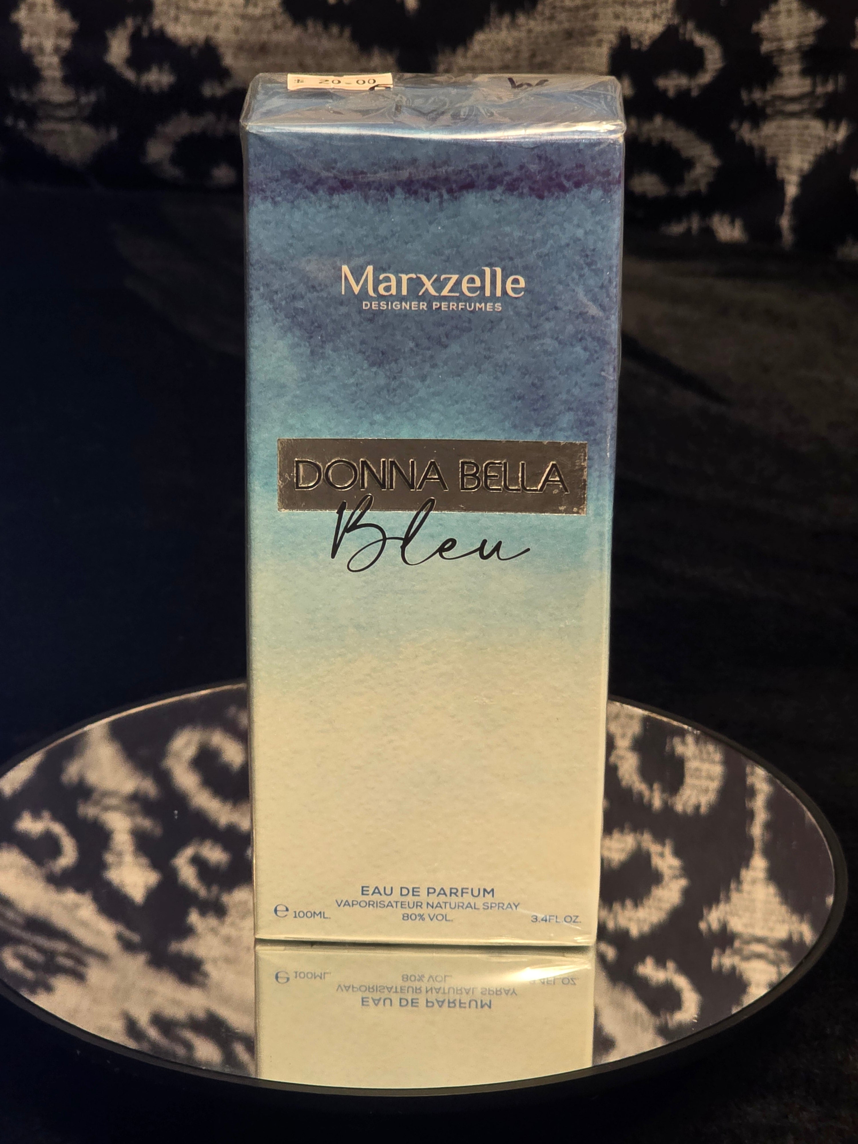 Marxzelle Donna Bella Bleu Eau de Parfum 100mL box - dreamy blue to white watercolor ombre gradient packaging with deep navy top, silver DONNA BELLA Bleu metal plate label and gold Marxzelle header